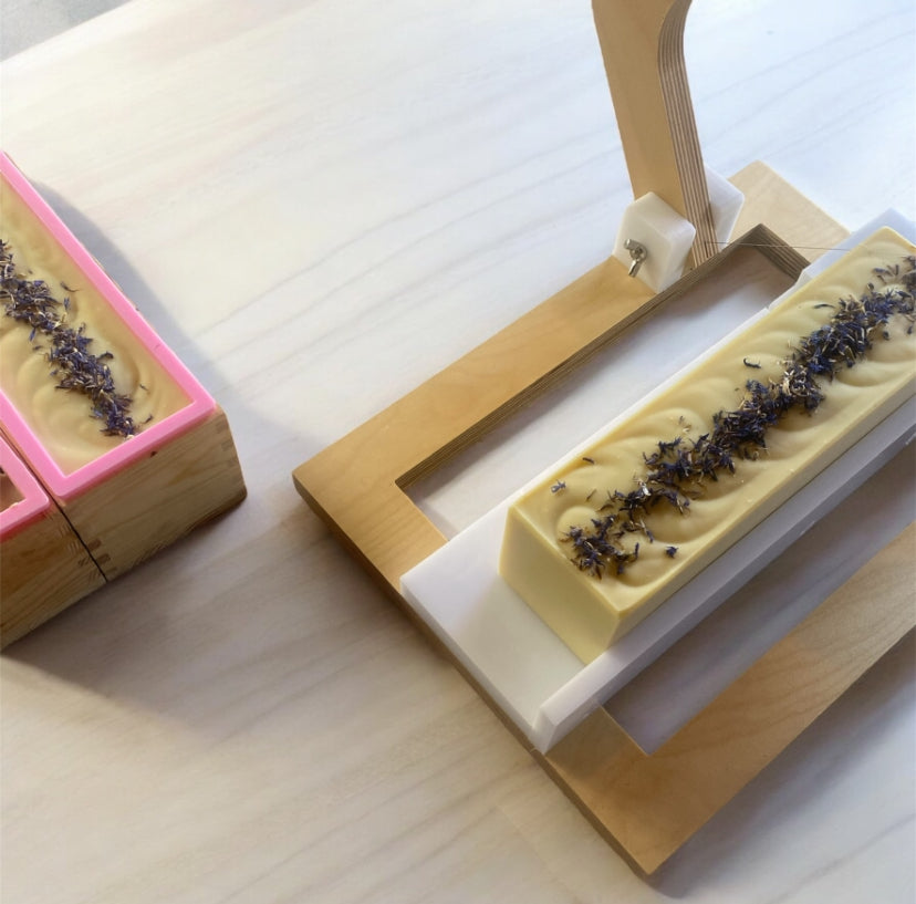 Rectangular soap bars with cornflowers on a wooden stand and molds
