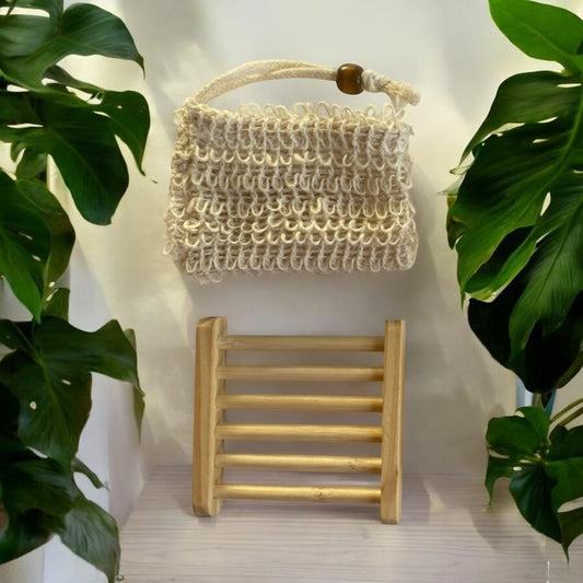 Sisal bag and wooden Soap holder against a light background with plants on either side